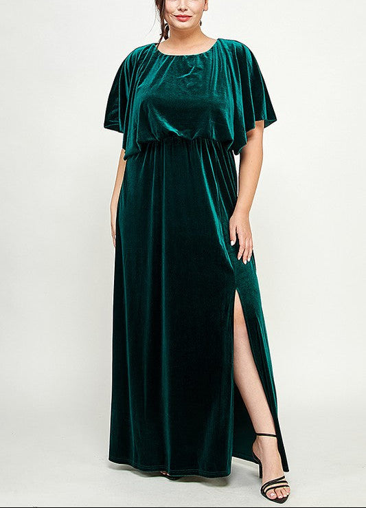 Woman wearing a green velvet dress with a slit on a white background